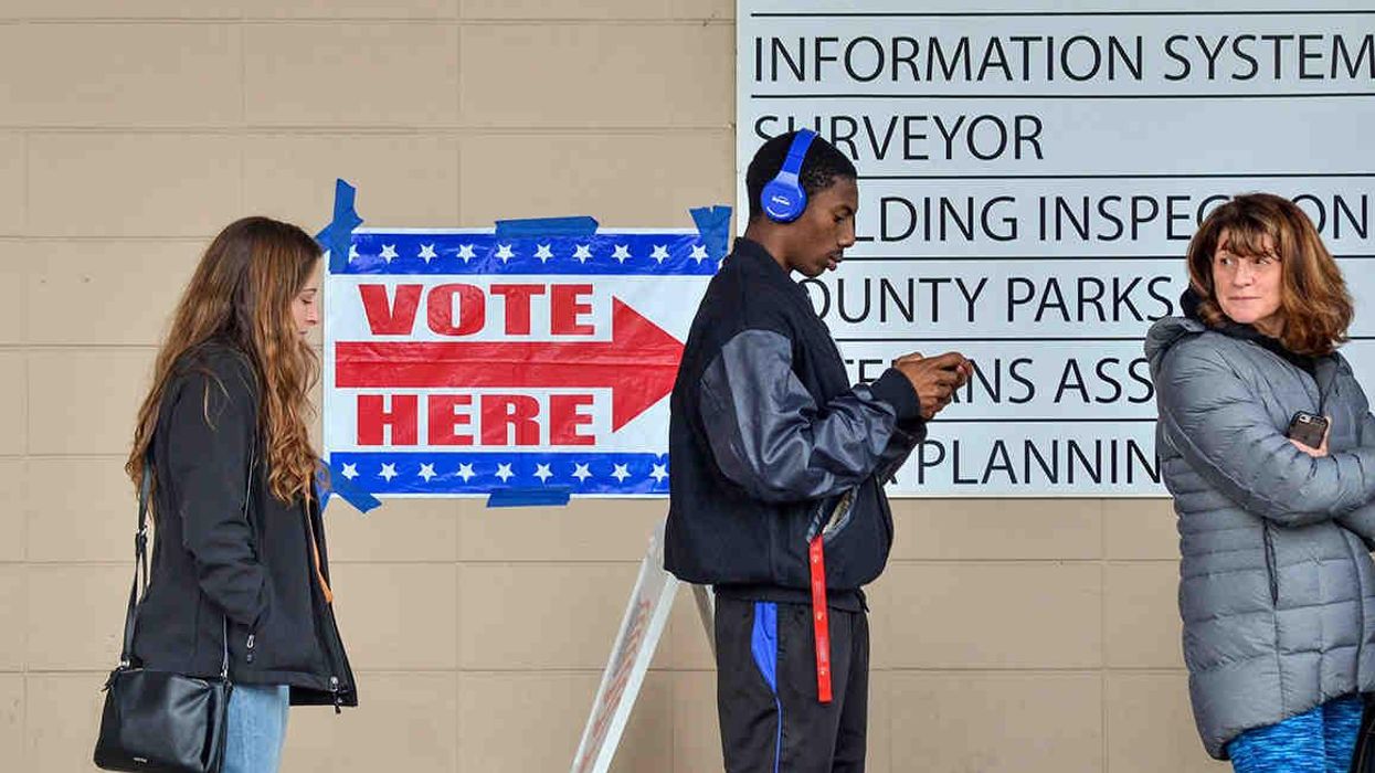 People stand on line waiting to vote.