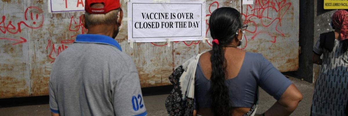 People standing near the gate of a vaccination center.