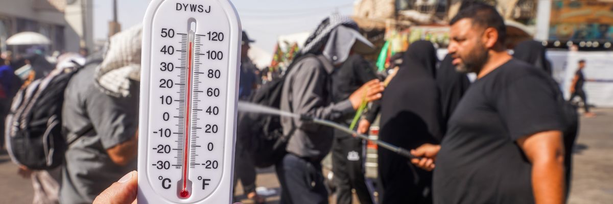 People try to protect themselves from the sun and cool off in Najaf, Iraq
