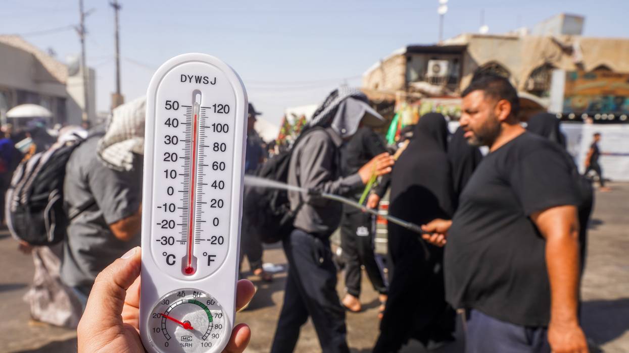 People try to protect themselves from the sun and cool off in Najaf, Iraq