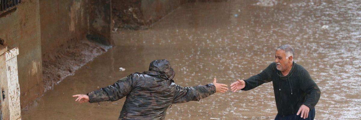 People wade through a flooded street during heavy rain in Sanliurfa, Turkiye