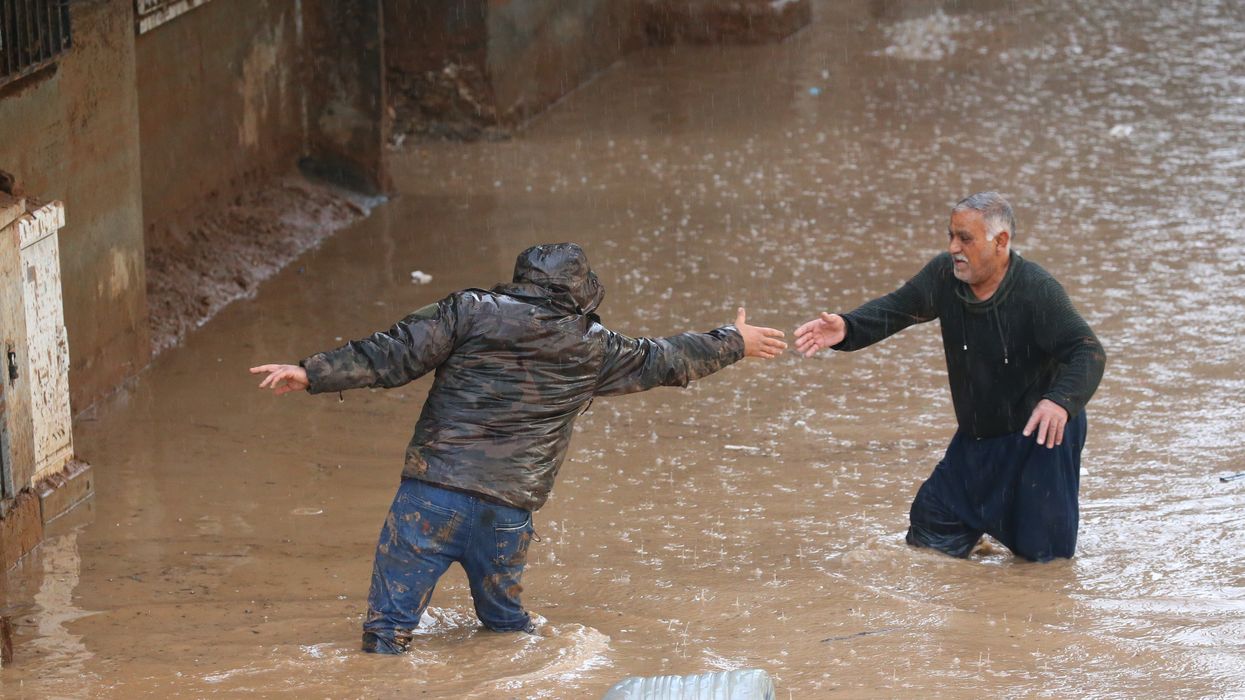 People wade through a flooded street during heavy rain in Sanliurfa, Turkiye