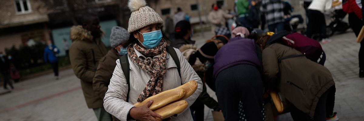 People wait in line to receive food aid