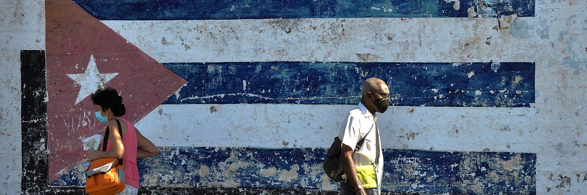 People walk near a mural depicting a Cuban flag in Havana on April 16, 2021.