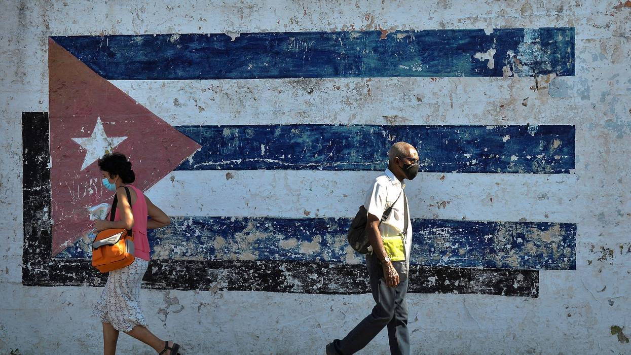 People walk near a mural depicting a Cuban flag in Havana on April 16, 2021.