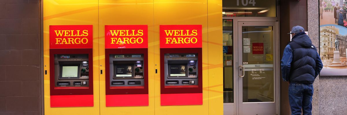 People walk past a Wells Fargo bank