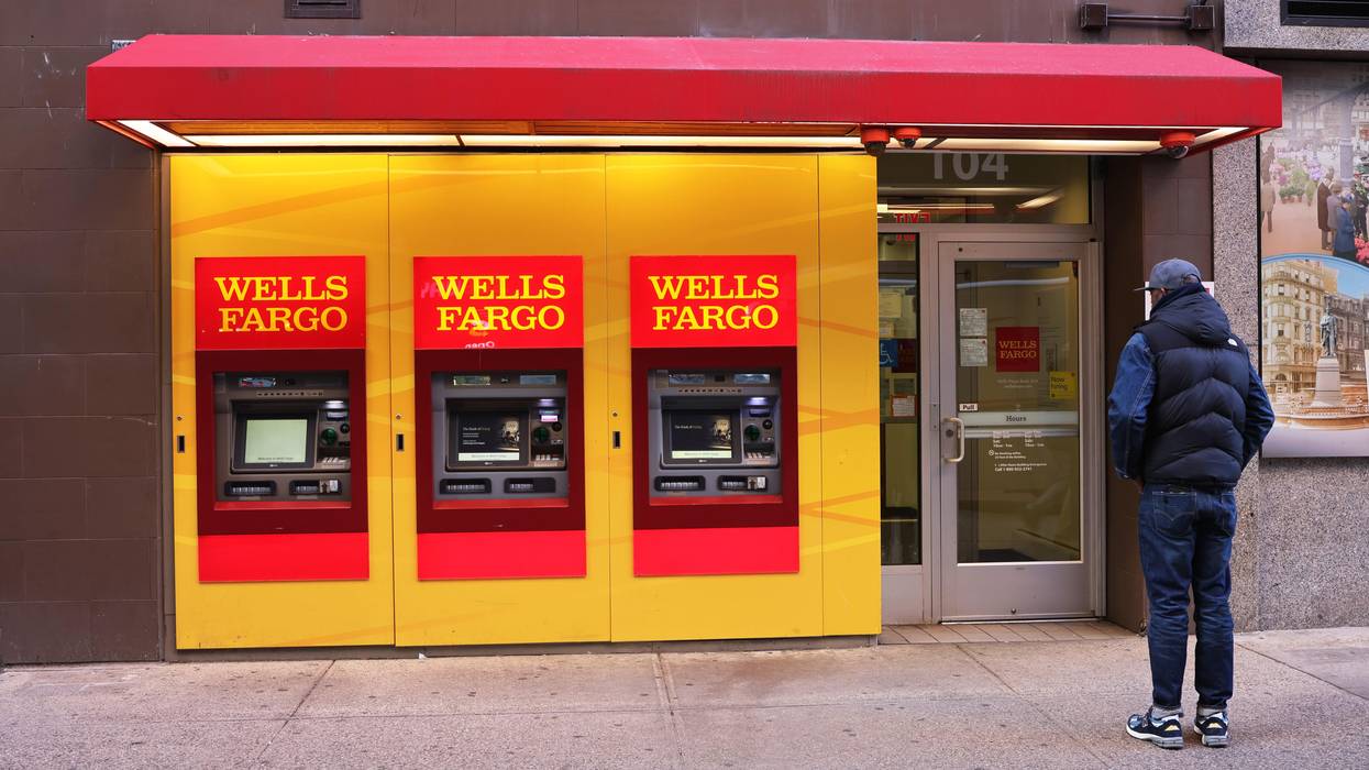 People walk past a Wells Fargo bank
