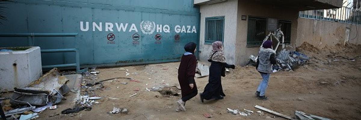 People walk past the headquarters of the United Nations Relief and Works Agency for Palestine Refugees in the Near East