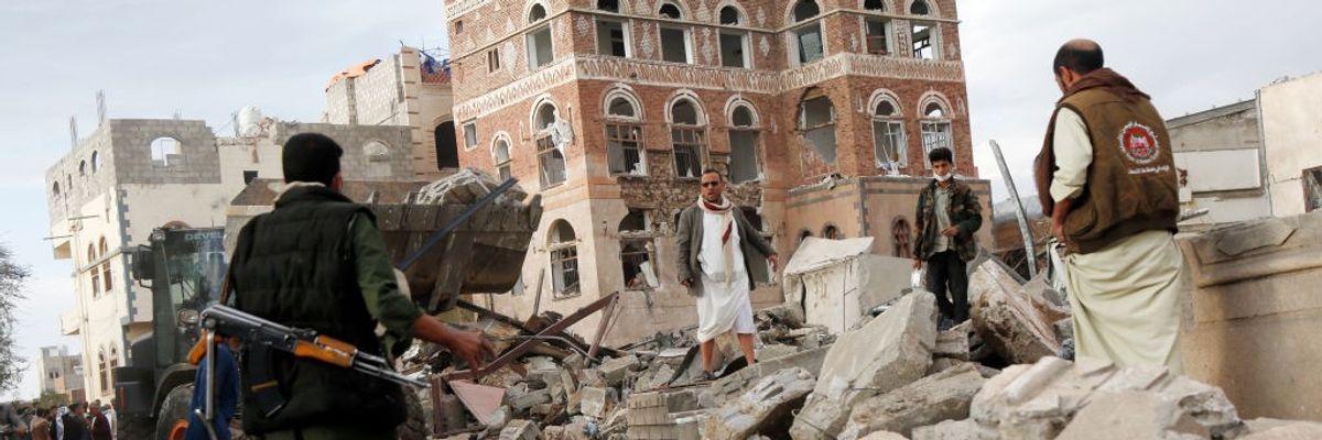 People walk through a building bombed by the U.S. in Yemen.