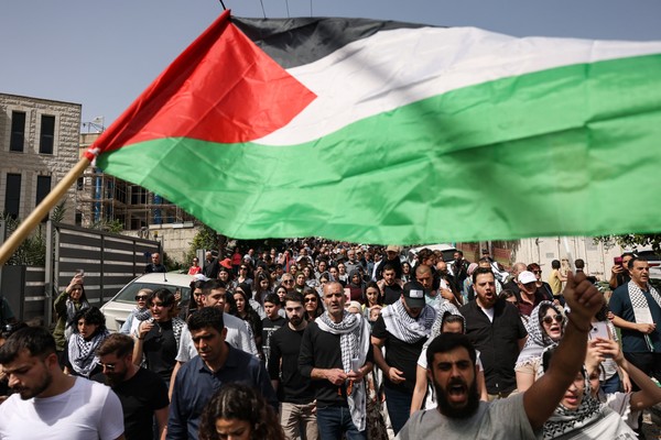 People wave Palestinian national flags