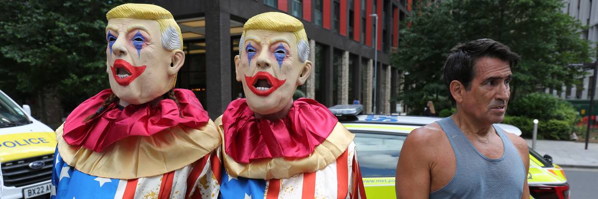 People wear clown costumes and Trump masks.