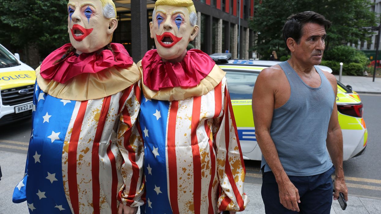 People wear clown costumes and Trump masks.