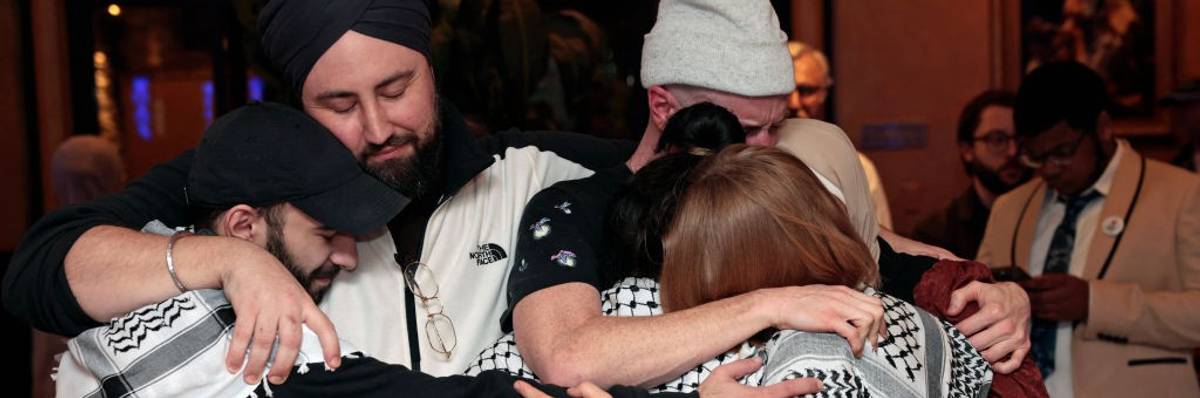 People with Listen to Michigan group hug after state's primary results came in