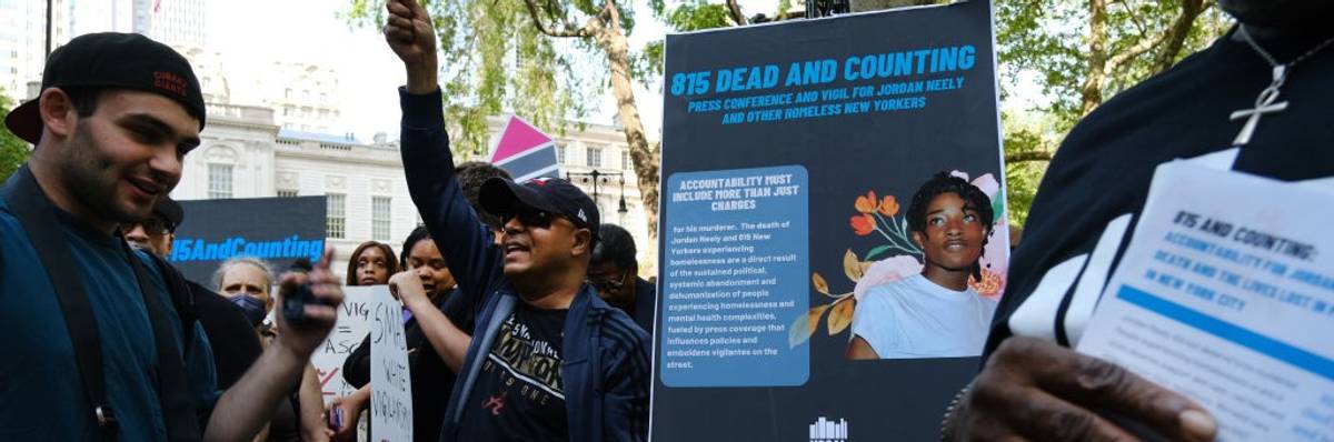 People with signs in a park.