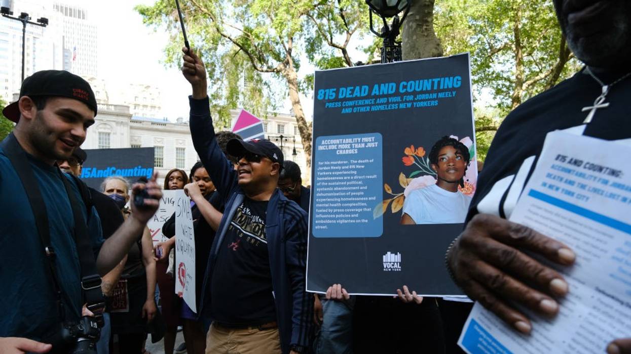 People with signs in a park.