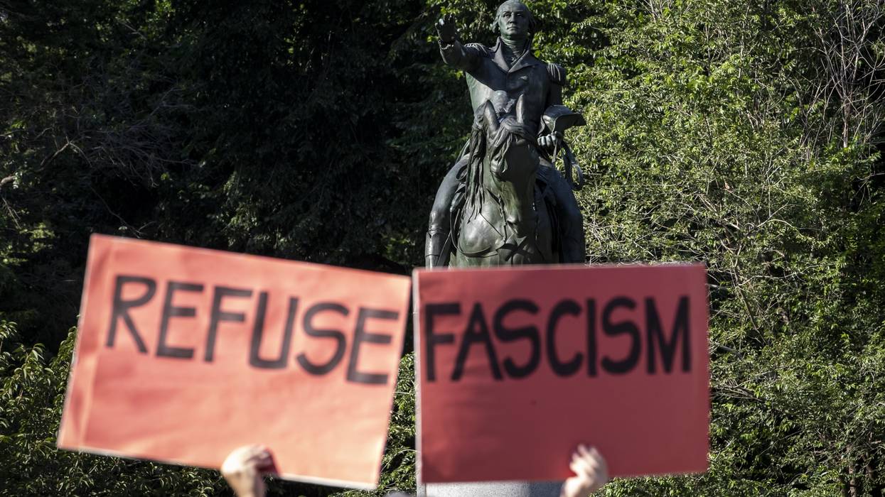 Person carries signs saying, "Refuse fascism."