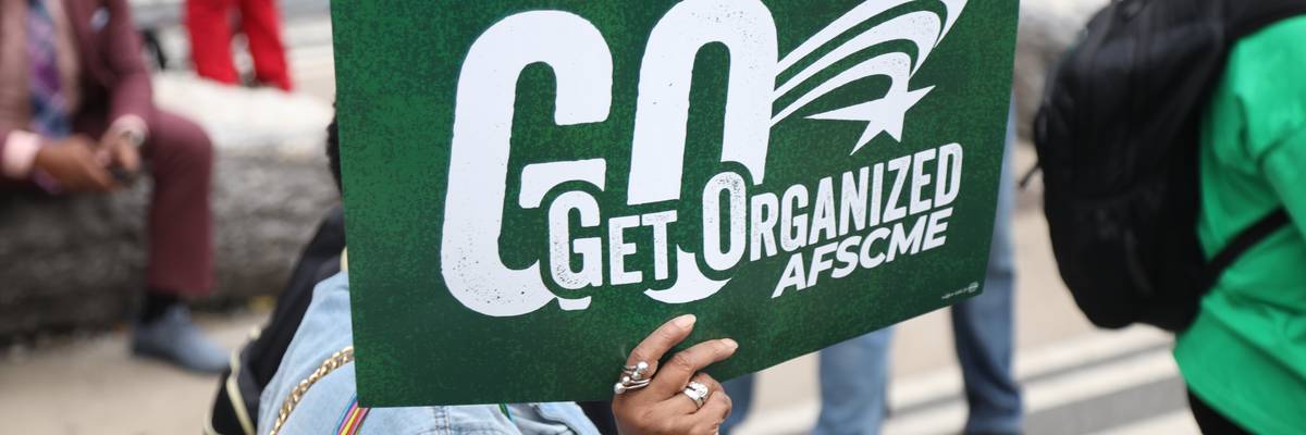 Person holds up an AFSCME sign during the 2025 National Action Network March on Wall Street.