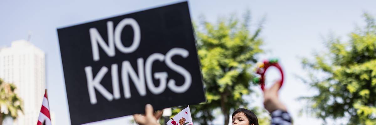 Person holds up sign reading, "No Kings."