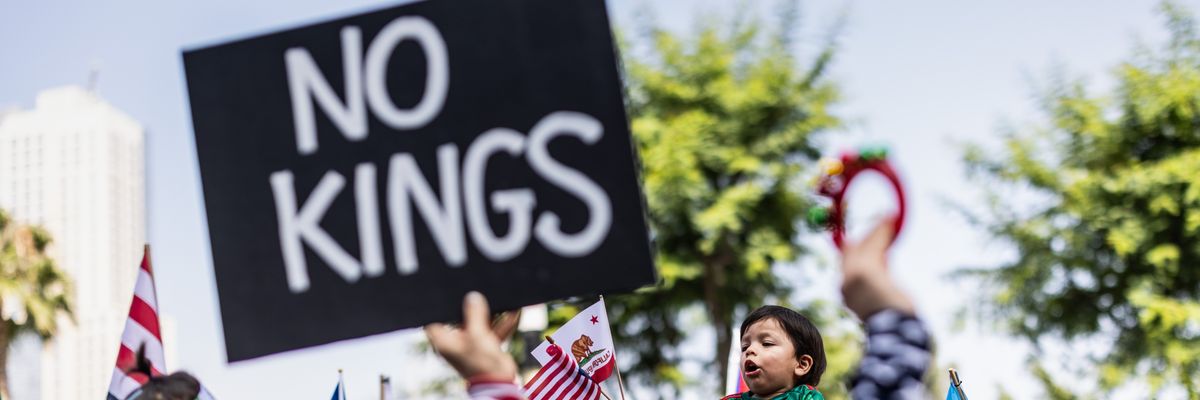 Person holds up sign reading, "No Kings."