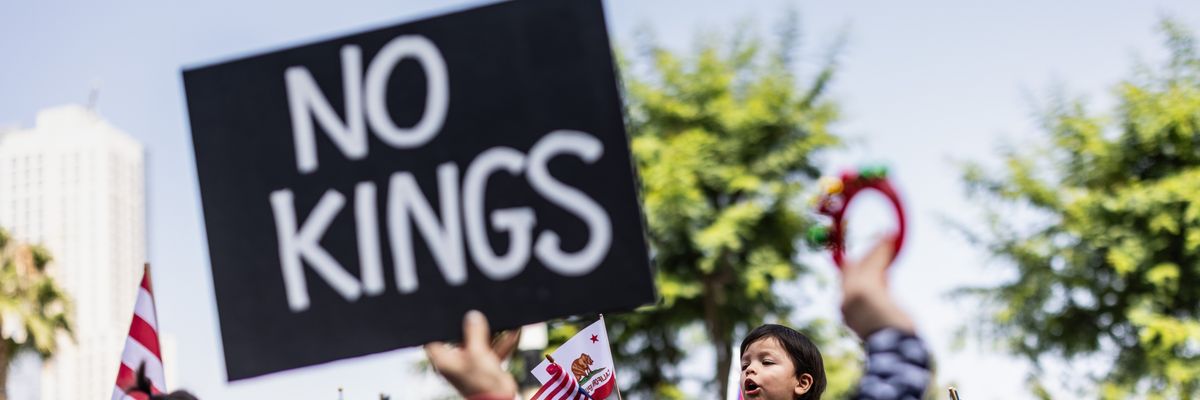 Person holds up sign reading, "No Kings."