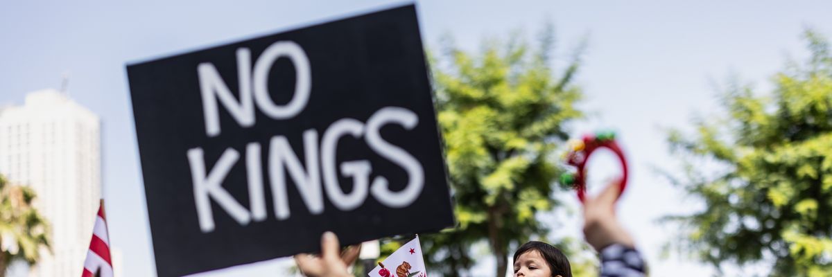 Person holds up sign reading, "No Kings."