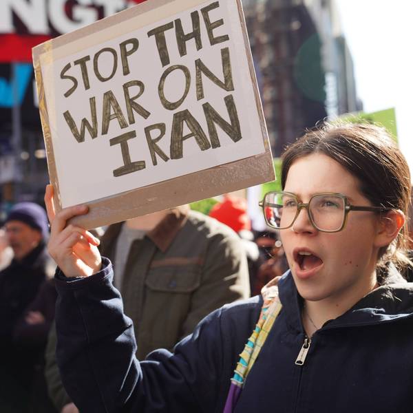 Person holds up sign reading, "Stop the War on Iran."