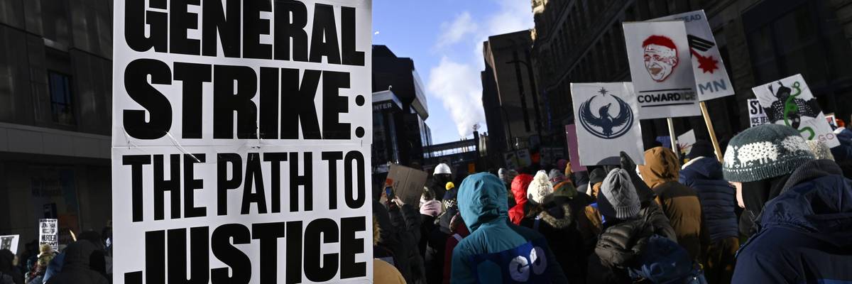 Person in Minneapolis protest holds sign reading "General strike: Path to justice."