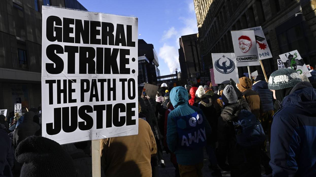 Person in Minneapolis protest holds sign reading "General strike: Path to justice."