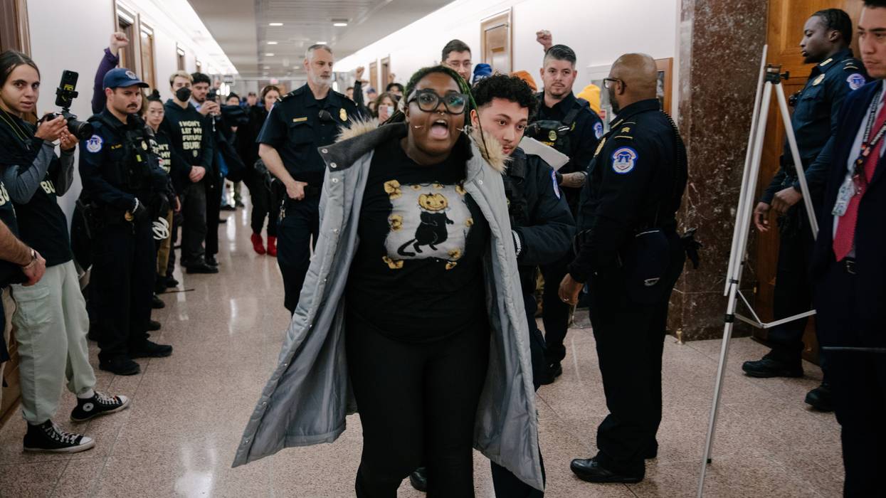 Person shouts as they are forced down a hallway by police.