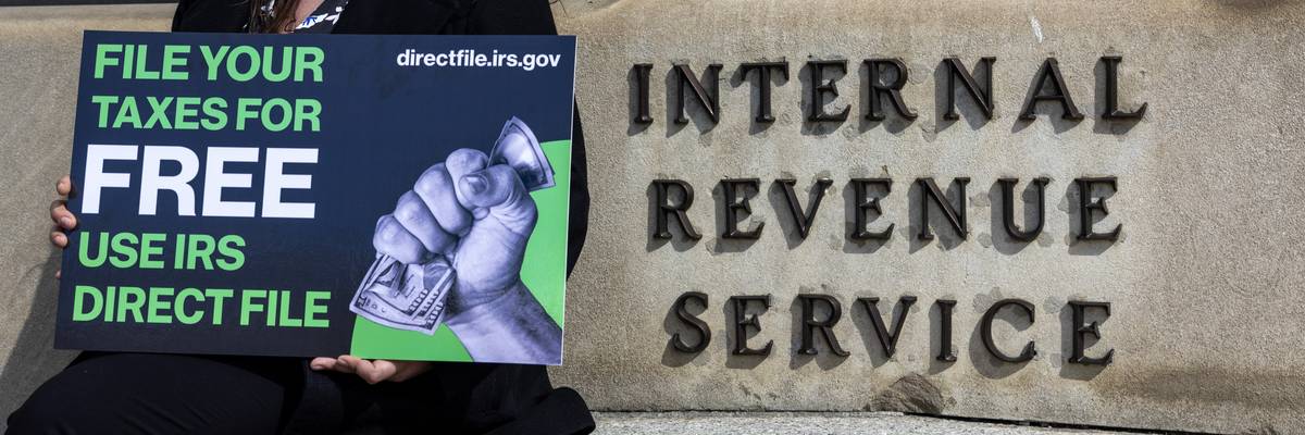 Person stands outside IRS building advocating for Direct File.