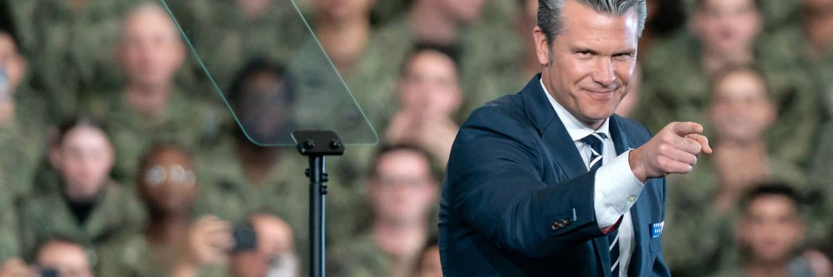 Pete Hegseth points; a crowd of US troops is in the background