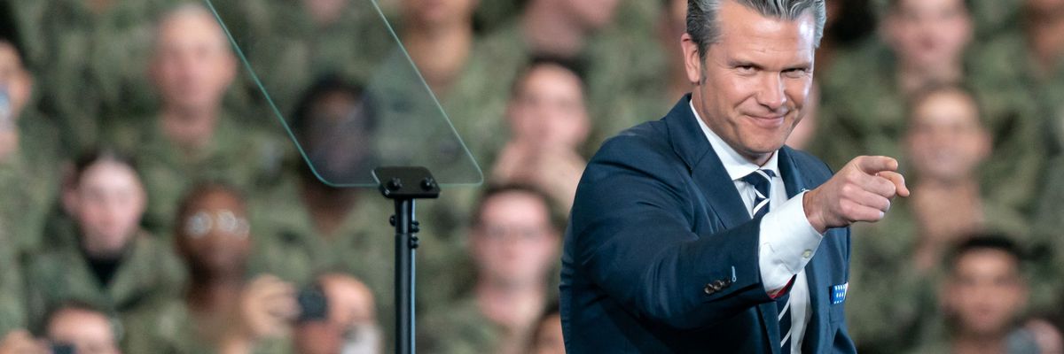 Pete Hegseth points; a crowd of US troops is in the background