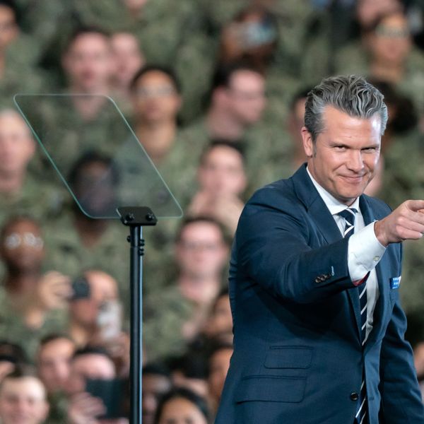 Pete Hegseth points; a crowd of US troops is in the background