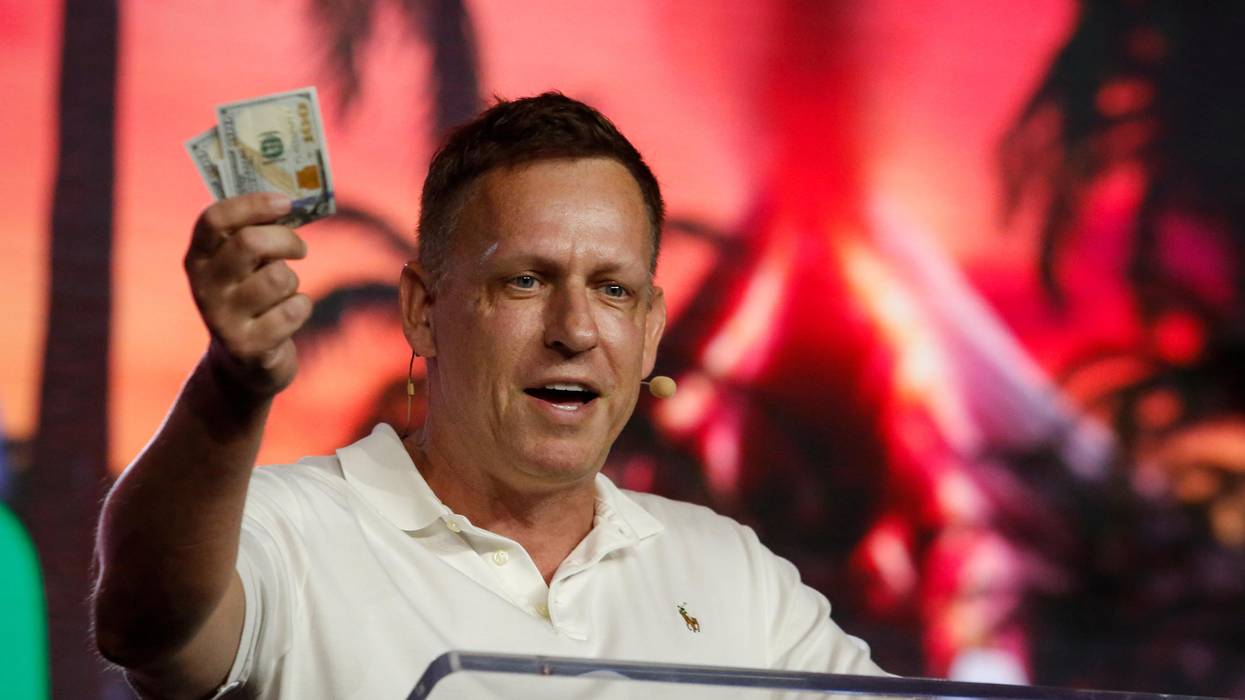 Peter Thiel holds up $100 bills.