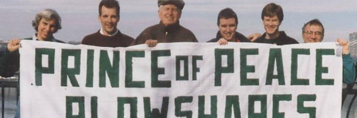 Philip Berrigan and other activists hold up a banner for the Plowshares Movement.
