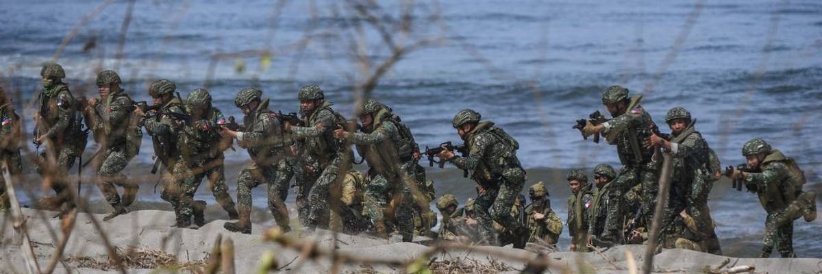 Philippine soldiers take position on a beach during a joint exercise