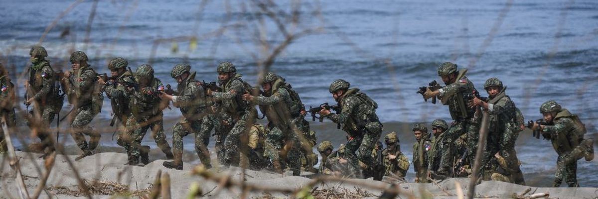 Philippine soldiers take position on a beach during a joint exercise