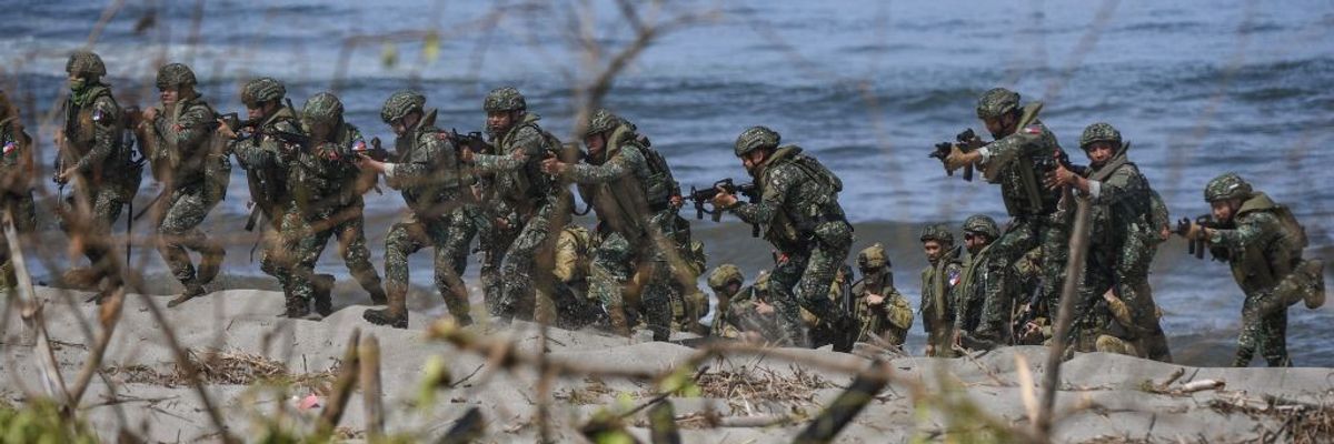Philippine soldiers take position on a beach during a joint exercise