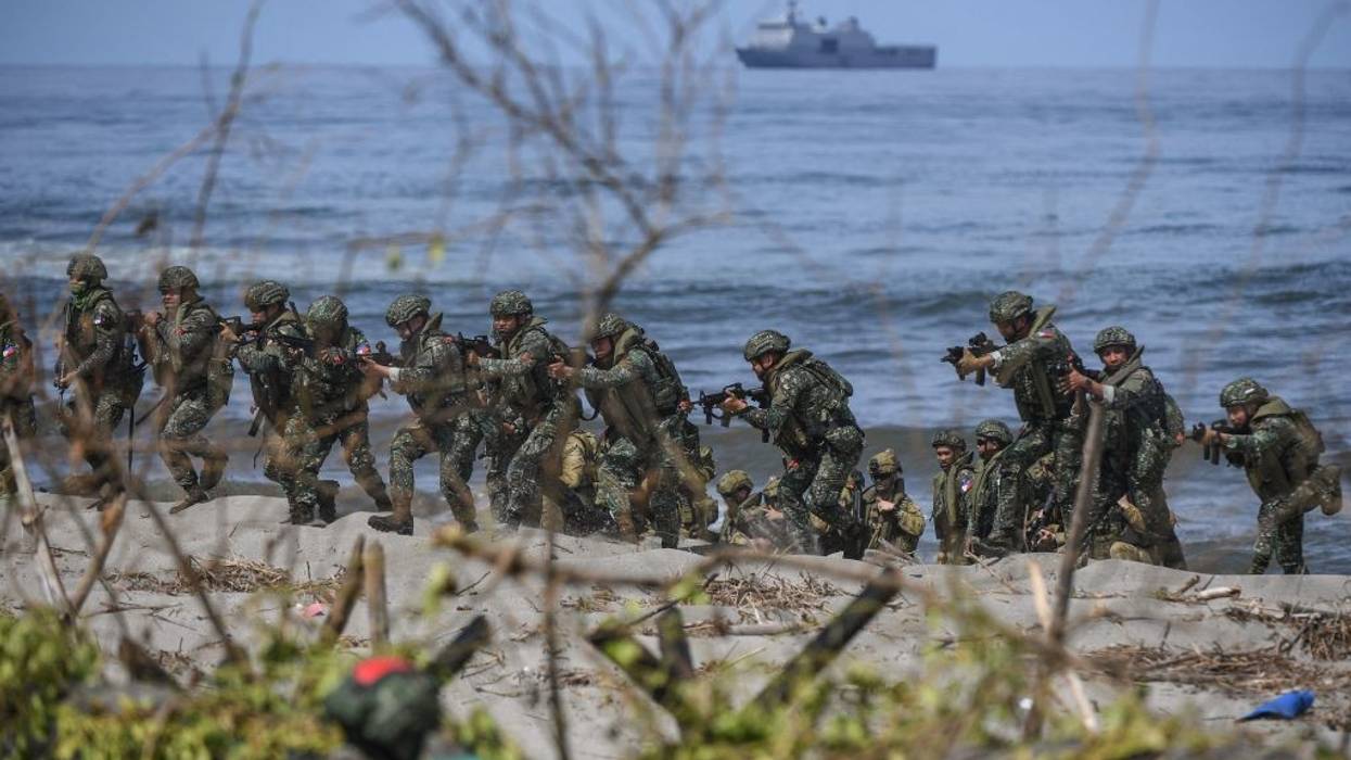 Philippine soldiers take position on a beach during a joint exercise