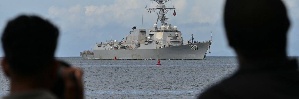 Photographers take pictures as the USS Gravely warship enters the Port of Spain