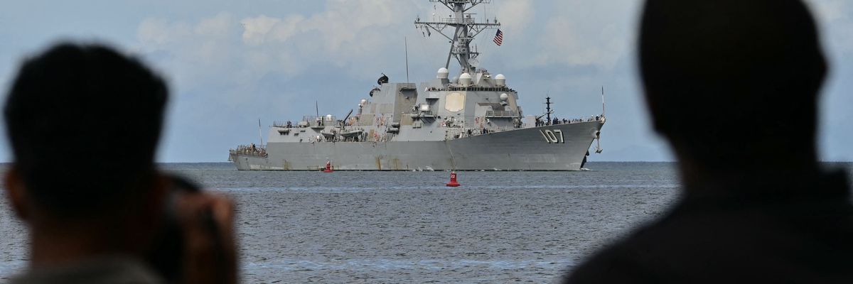 Photographers take pictures as the USS Gravely warship enters the Port of Spain