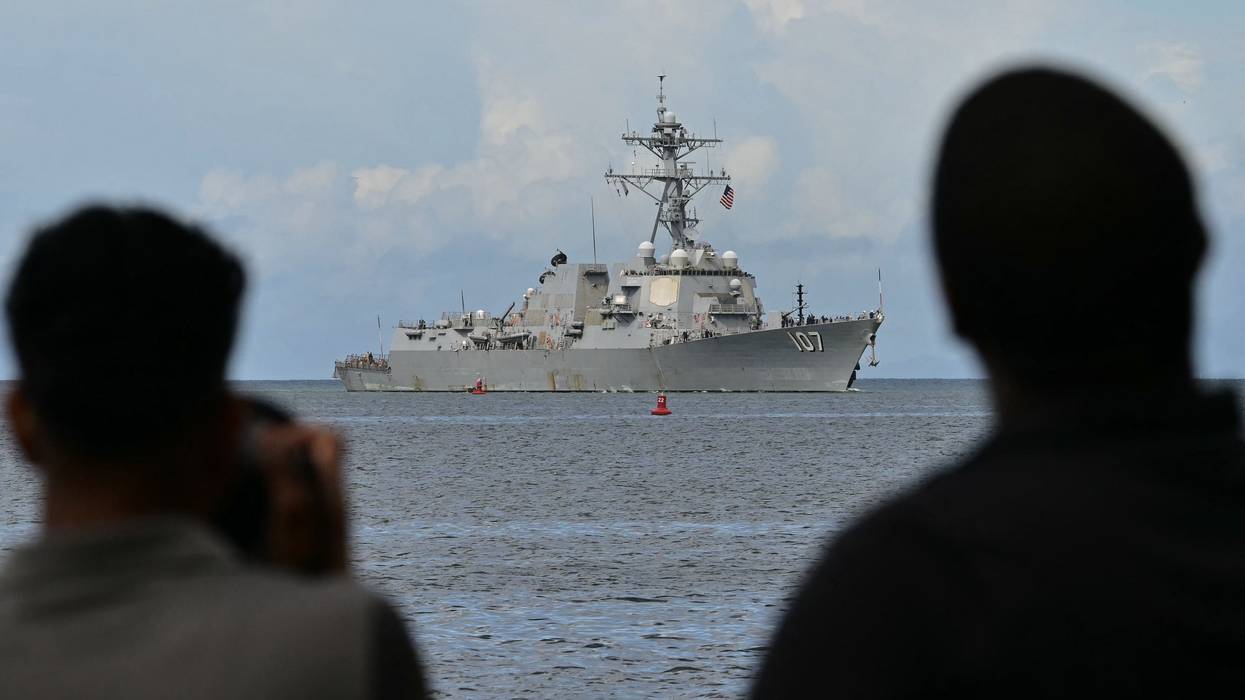Photographers take pictures as the USS Gravely warship enters the Port of Spain
