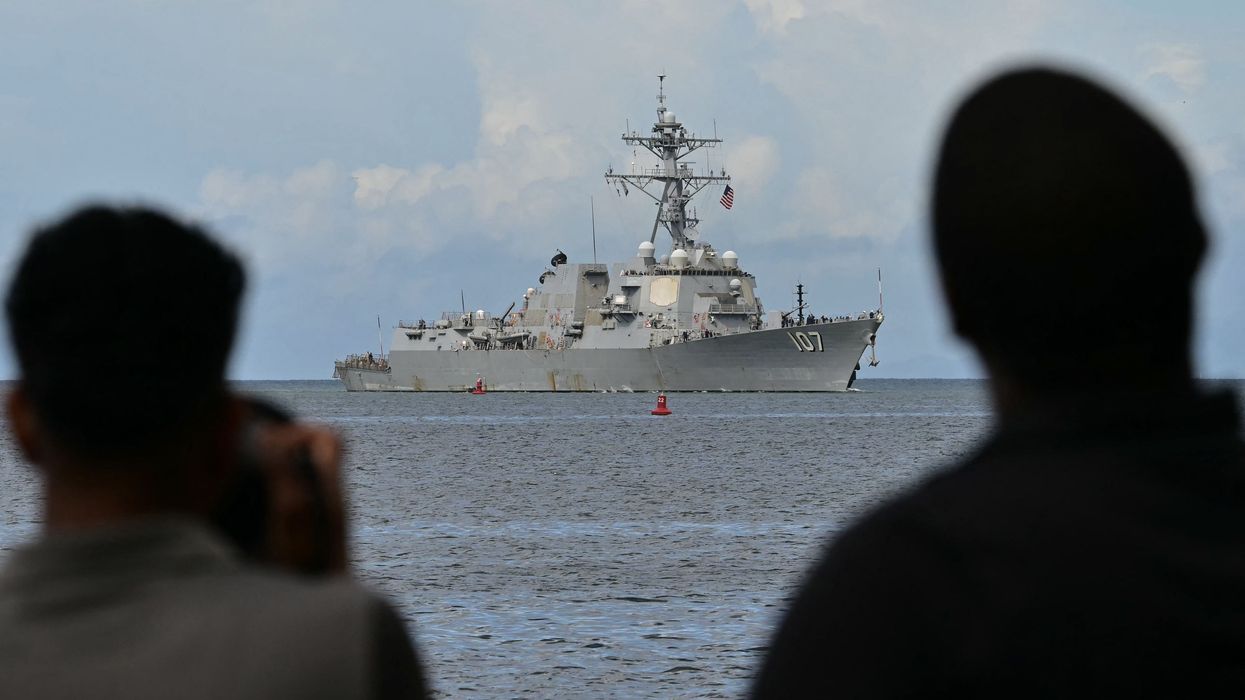 Photographers take pictures as the USS Gravely warship enters the Port of Spain