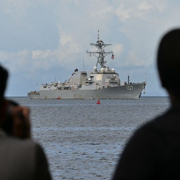 Photographers take pictures as the USS Gravely warship enters the Port of Spain