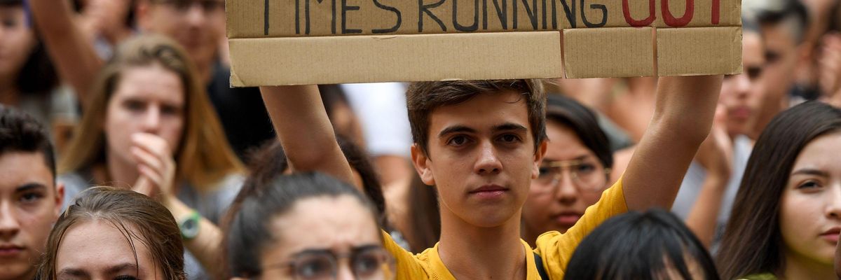Placard reads: Time's running out
