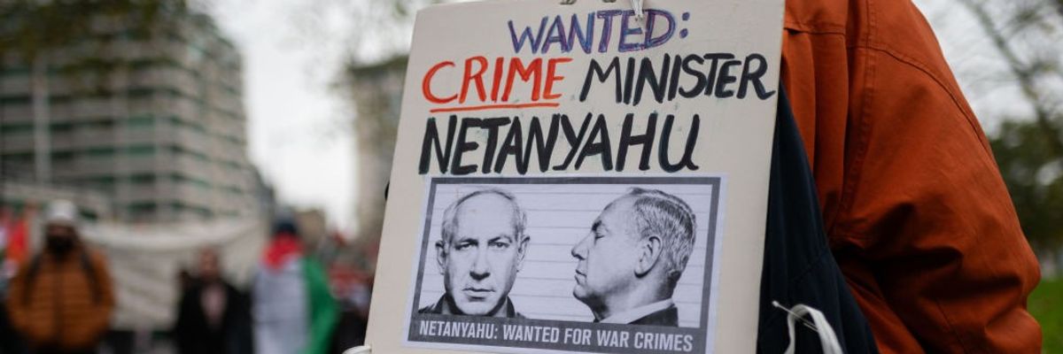 Placard says "Wanted: Crime Minister Netanyahu"