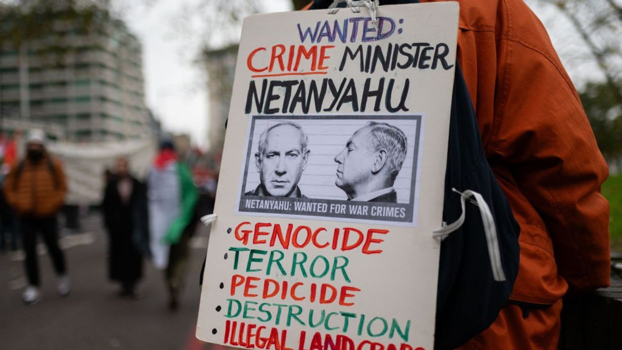 Placard says "Wanted: Crime Minister Netanyahu"