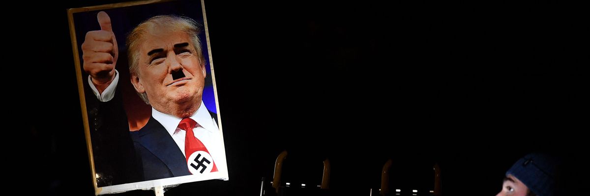 Placard showing picture of Trump with Hitler-style mustache