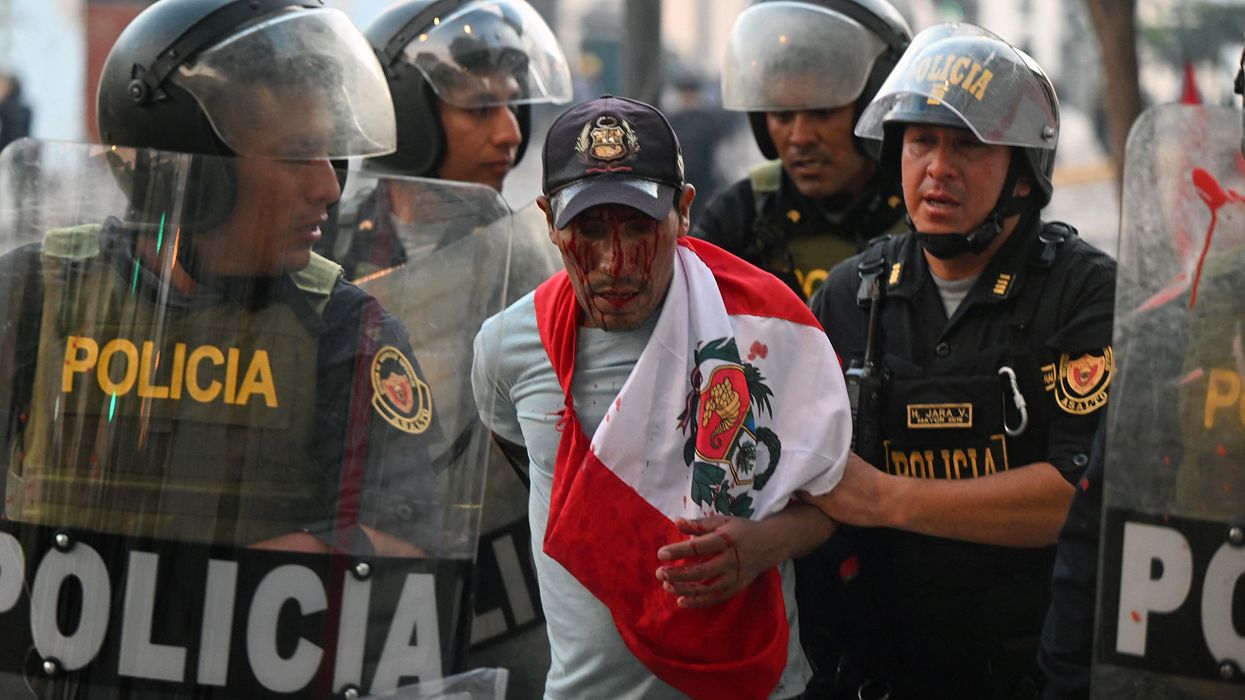 Police arrest a demonstrator during a protest in Lima
