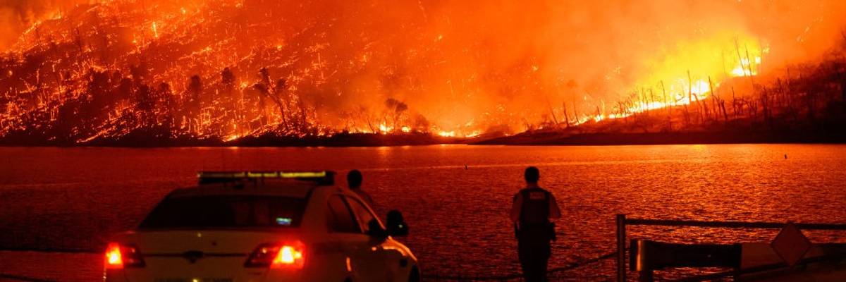 Police look on as forest fire burns in Oroville